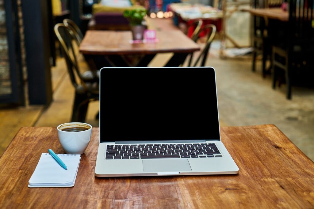 Image of laptop on table in coffee shop.