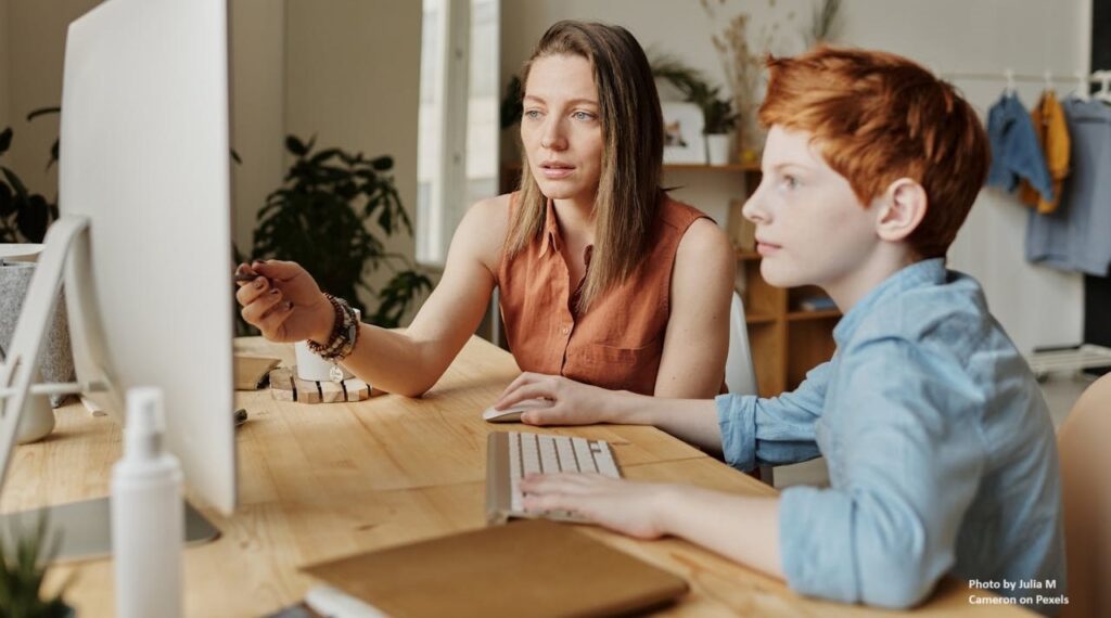 Photo of woman and boy watching a computer screen.
