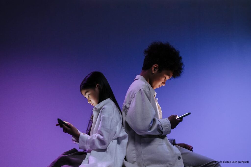 Photo of two kids on smartphones.