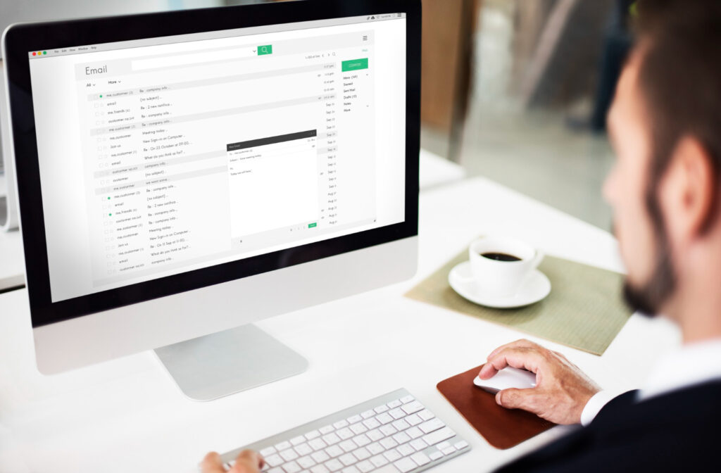 Image of a man looking at a screen showing his email.