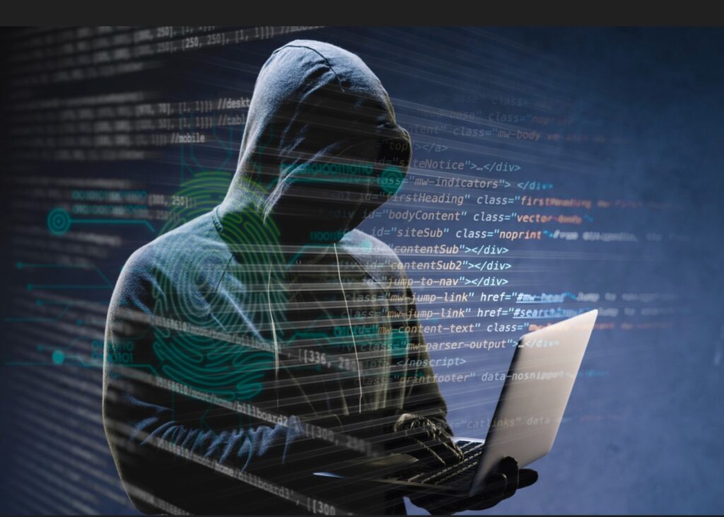 A hooded figure using a laptop, surrounded by digital code and biometric overlays, symbolizing cyber threats—ideal for illustrating Dark Web Monitoring for Executives.