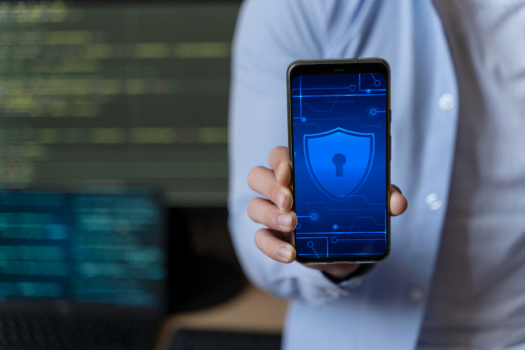 Close up of someone holding phone with a security lock on the screen, showing how to protect against digital kidnapping